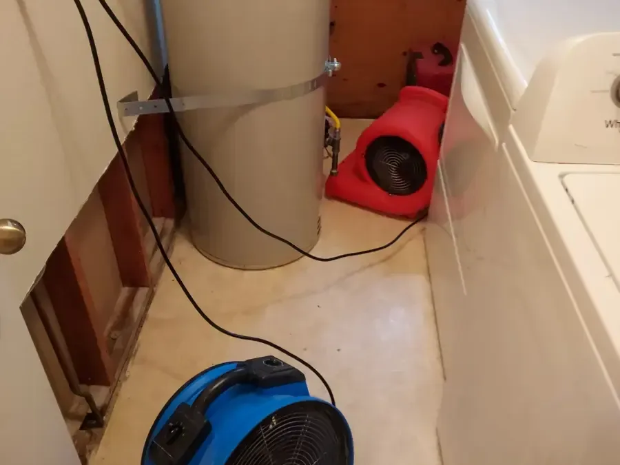 Drying fans sit beside an opened wall in a laundry area