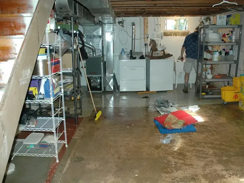 Water covers a utility room floor in front of laundry appliances