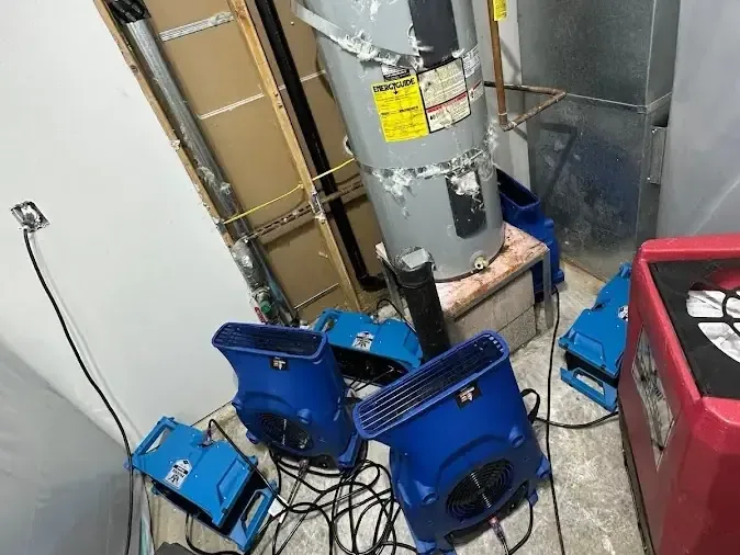 Drying equipment and cables surround a water heater in an opened closet